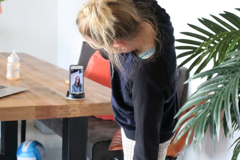 Cliënt doet thuis een oefening en volgt de video op de telefoon