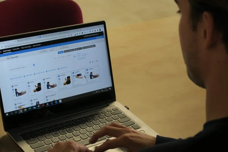 Zorgverlener stelt op een laptop een oefenprogramma samen in HWO